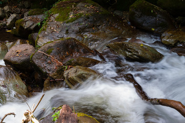 Closeup of water flowing around rocks with motion blur
