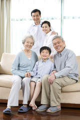 Fototapeta na wymiar Grandparents and Parents pose with son on sofa