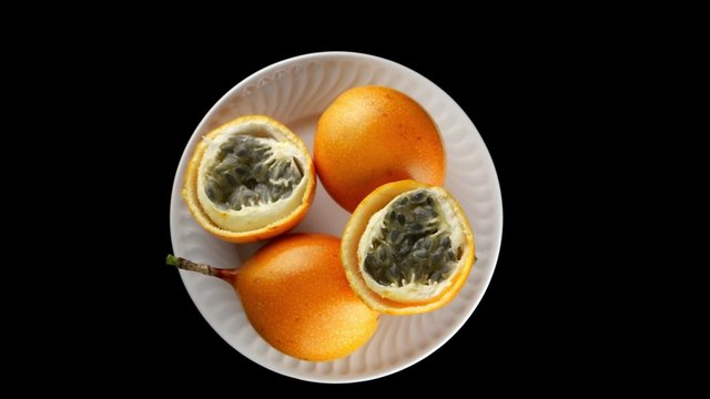 Passion fruit maracuja granadilla on black background.