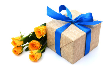 gift box with blue ribbon bow and yellow roses on white background