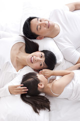 Obraz na płótnie Canvas Happy family lying in bed