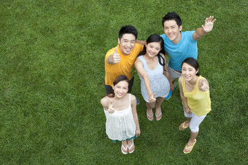 Fototapeta premium Young people doing thumbs-up on meadow