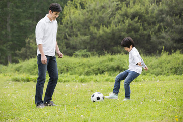 Happy father and son playing football together