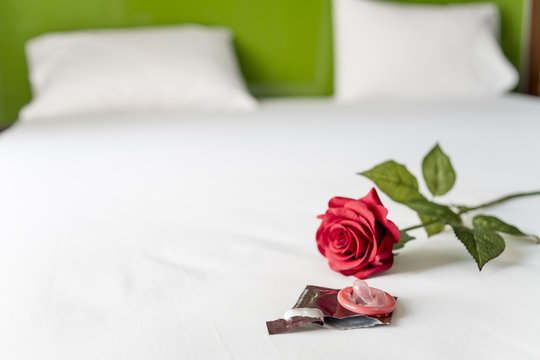 Condom and red rose on bed, Valentine concept