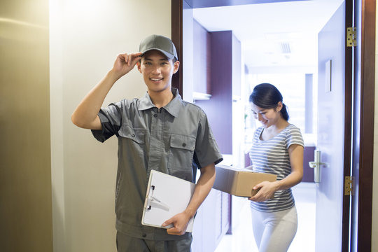Young woman getting a package from delivery person