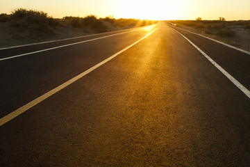 Road going through wilderness area in the glow of setting sun, China