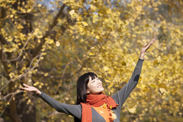 Happy young woman appreciating the golden autumn