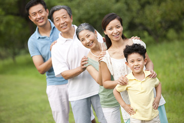 Happy family standing in a row outdoors