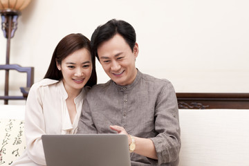 Happy couple using laptop