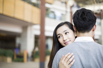 Young couple embracing in shopping mall