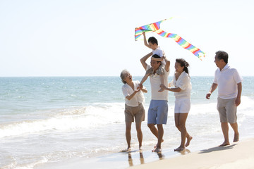 Family playing at the beach - obrazy, fototapety, plakaty