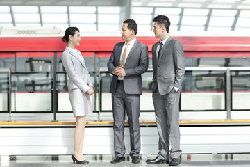 Business persons talking at subway station