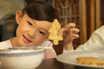 Girl Holding Up Christmas Tree Shaped Cookie