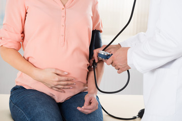 Doctor Checking Pregnant Woman's Blood Pressure
