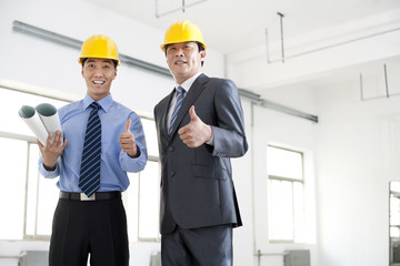 Excited businessmen giving thumbs up