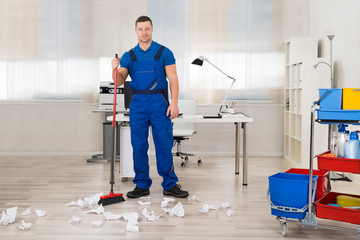 Janitor Cleaning Floor With Broom In Office