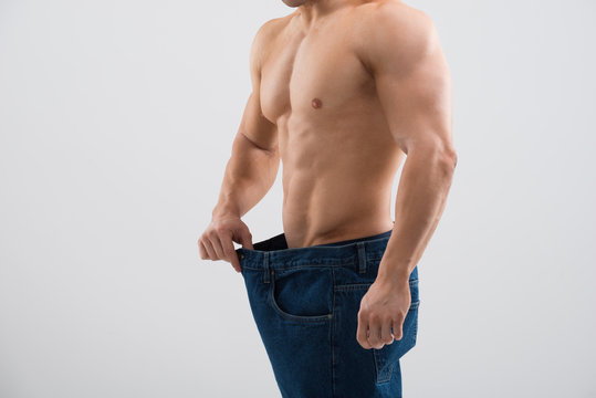 Muscular Man In Old Jeans Showing Weight Loss