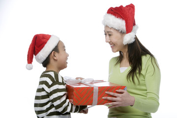 Mother and son with Santa hats holding gift box
