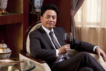 Mature businessman enjoying wine in a luxurious room