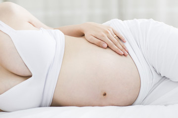 Fototapeta na wymiar Pregnant woman lying in bed