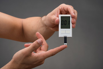 Man Checking Blood Sugar Level With Glucometer
