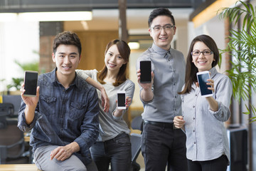 Obraz premium IT workers showing smart phones in office