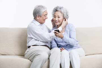 Senior couple enjoying music in living room
