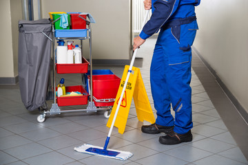 Janitor With Broom Cleaning Office Corridor