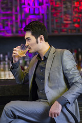 Young man having a drink at bar