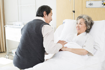 Fototapeta premium Senior man taking care of wife in hospital
