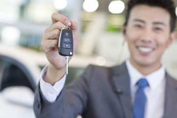 Salesman showing car key