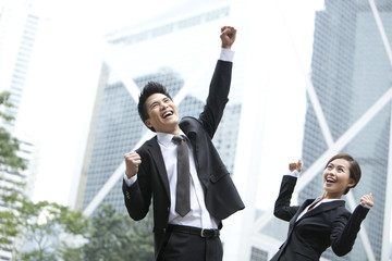 Excited business colleagues punching the air outdoors, Hong Kong