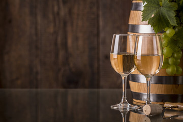 Glasses of wine with barrel and grapes