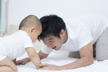 Obraz na płótnie Canvas Real Chinese father and son playing in bed