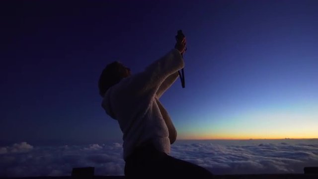Selfie, Tourist travel photographer photographing selfie sunset view on top of mountain above the clouds.
