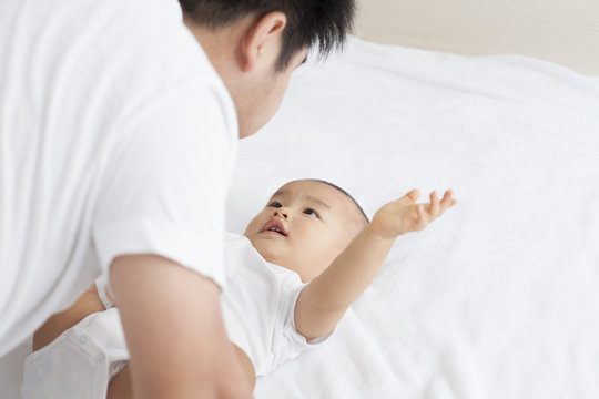 Chinese father and son playing in bed