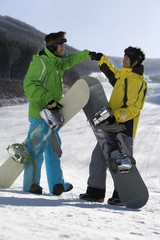 Two young men with their snowboards