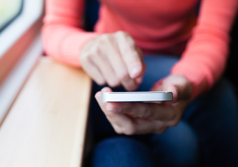 Woman using her phone on a train.
