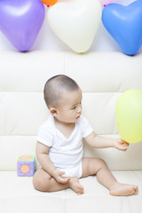 Fototapeta na wymiar Chinese baby boy and colorful balloons