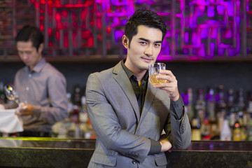 Young man having a drink at bar