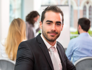 Young attractive businessman working at the office with associat