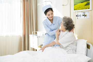 Obraz na płótnie Canvas Nurse giving shoulder massage to senior woman in hospital