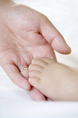 Hand holding infant foot