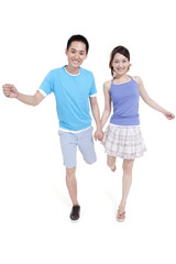 Happy young couple running hand in hand