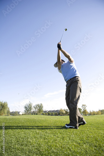 Man Swinging Golf Club On Golf Course Stock Photo And