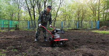 Man working in the garden preparing ground cultivator