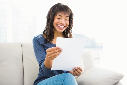 Casual smiling woman reading paper