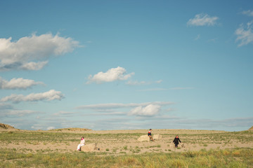 Landscape with people. Three people sitting in a field on the rocks