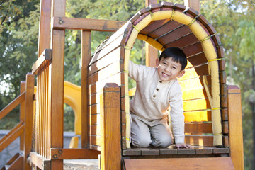 Boy crawling through tunnel in playground