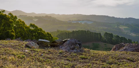 Foto op Plexiglas Uitzicht op de vallei vanaf de rotsachtige top van de heuvel laat in de middag landschap © mastersky